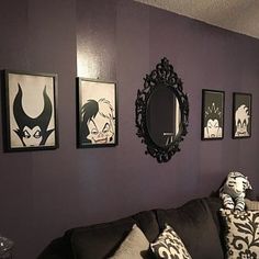 a living room with purple walls and pictures on the wall above the black couches