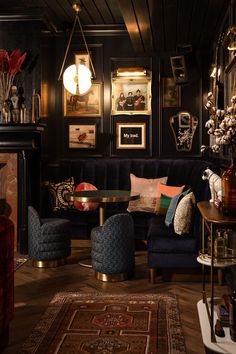 a living room filled with lots of furniture and pictures on the wall next to a fire place