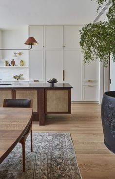 a large potted plant sitting on top of a wooden table next to a kitchen counter