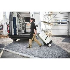 a man carrying two suitcases into the back of a van