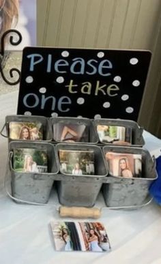 there is a sign that says please take one with pictures in buckets on the table