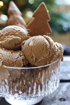 a glass bowl filled with ice cream next to a christmas tree