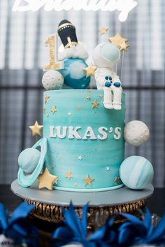 a blue cake with stars and an astronaut on top