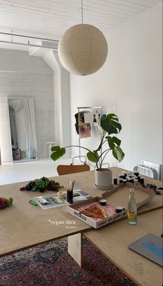 a table with food and plants on it in front of a mirror that is hanging from the ceiling