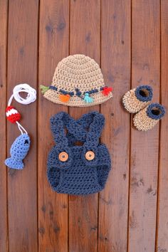 several crocheted items are laid out on a wooden surface, including a hat and booties