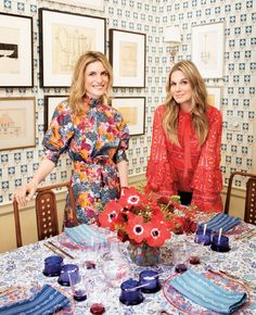 two women sitting at a table with plates and cups