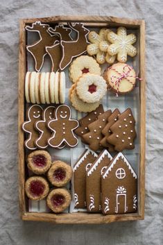 a wooden box filled with lots of different types of cookies and pastries on top of a table