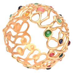 The open sculptural design of the gold plated wide cuff bracelet with amazing The luscious jewel tone colored stones large cuff make this a statement piece. It has a very Yves St Laurent look to it! It is like the tree of life in circular form. The colors are luscious and are rich looking. They range in color from light green to dark green, orange, navy blue,red, salmon pink, yellow mustard, etc. The interior of the cuff to pull over your wrist is 2.5" D. The height of the bracelet is 2.5" H Thi Yves St Laurent, Stone Bangles, Bracelet Stone, St Laurent, Jewel Tone Colors, Wide Cuff Bracelets, Gold Plated Bangles, Gold Armband, Bracelets Gold