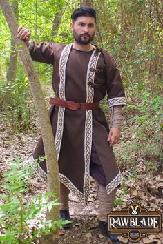 Introducing the Nuada Tunic by Rawblade, a meticulously designed medieval garment crafted to enhance your outfit for LARP events or Renaissance Faires. This unisex tunic, available in classic brown and black shades, features intricate Celtic embroidery that perfectly blends authenticity and style. Suitable for both men and women, the Nuada Tunic is an excellent choice for historical reenactments, fantasy gatherings, and costume parties. Made from high-quality materials, this tunic provides excep Minecraft Movie, Celtic Embroidery, Medieval Tunic, Medieval Peasant, Formal Cocktail Party, Tunic Designs, Historical Reenactment, Costume Parties, Garden Party Dress