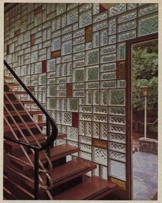 a stair case next to a window with glass blocks on the wall and wooden steps