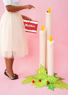 a woman in a white dress holding a red and white sign next to some candles