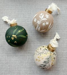 three decorative ornaments are sitting on the floor next to each other and one is green