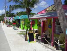 brightly colored buildings line the beach with palm trees