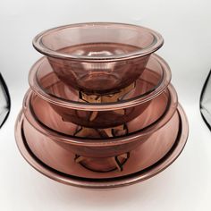 a stack of glass bowls sitting on top of each other in front of a white background