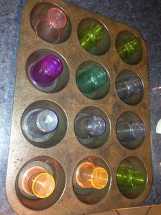 a muffin tin filled with lots of different colored cups