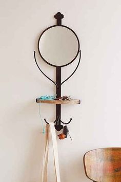 there is a mirror on the wall with a coat rack next to it