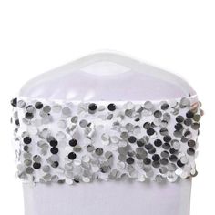 a white hat with black and silver sequins on the front, sitting on top of a mannequin