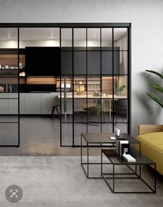 a living room filled with furniture next to a kitchen