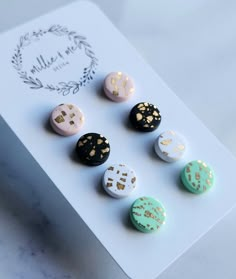 six different colored buttons sitting on top of a white board