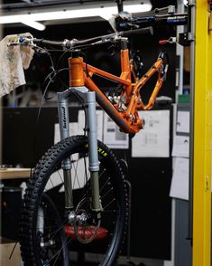 an orange bike is parked in a garage