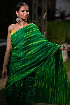 Upgrade your ethnic elegance with our Gia Green & Yellow Tie Dye Georgette Silk One Minute Saree. Crafted from luxurious raw silk, this stunning saree features a mesmerizing green-yellow tie-dye pattern. The pallu is adorned with vibrant yellow tassels, while the matching blouse comes with delicate spaghetti straps in yellow raw silk, adding a touch of sophistication to your traditional attire. Suitable for a summer night out, wedding party, pooja or any other function! About this Product Saree: Green Tussar Silk Traditional Wear With Cutdana, Green Semi-stitched Saree Traditional Wear, Semi-stitched Green Blouse Piece For Diwali, Green Art Silk Saree, Transitional Green Art Silk Saree, Designer Green Saree With Zari Weaving, Green Art Silk Blouse Piece For Diwali, Green Silk Blouse Piece With Cutdana, Green Semi-stitched Tussar Silk Traditional Wear