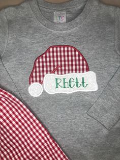 Get ready for holiday fun with this precious Santa hat shirt! This design looks great with a monogram on the brim of the hat! When ordering an embroidered item, please specify your desired design, monogram initials or name, monogram font & thread color. All of the monogram options can be found here. Also, please note any special requests in the box provided. We will try our best to comply. Applique Shirts, Font Names, Christmas Tree Design, Monogram Fonts, Tree Design, Tree Designs, Monogram Initials, Applique Designs, Santa Hat