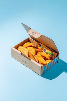 an open box of potato chips on a blue background