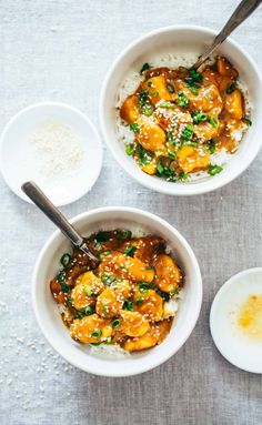 two bowls filled with chicken and rice on top of a table