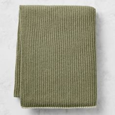 an olive green knitted blanket on a white background