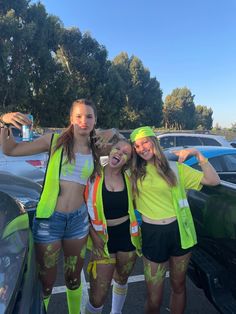 three girls in yellow vests and black shorts posing for the camera with their arms around each other