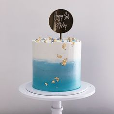 a blue and white ombrella cake with a happy birthday sign on top