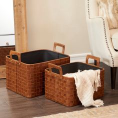 three brown baskets sitting on top of a wooden floor next to a chair and rug