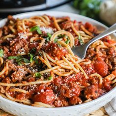 a white bowl filled with spaghetti and meat