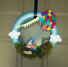 a door hanger with a house and hot air balloons in the shape of a wreath