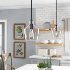 an image of a kitchen setting with lights hanging from the ceiling and dining room table in the foreground