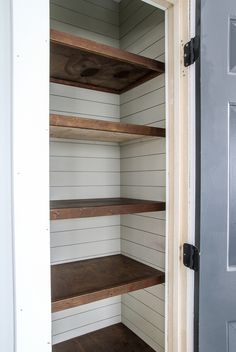 an empty pantry with wooden shelves in it