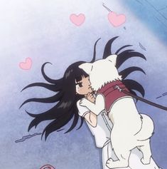 a woman hugging a dog with long black hair