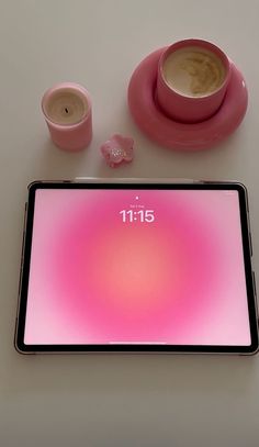 a tablet computer sitting on top of a table next to a coffee cup and saucer