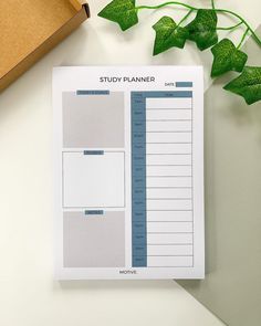 a study planner sitting on top of a table next to a box and green plant