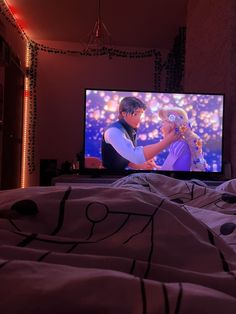 there is a tv screen with the image of disney and prince on it in bed