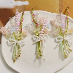 three flower shaped hair pins sitting on top of a white plate next to a toothbrush