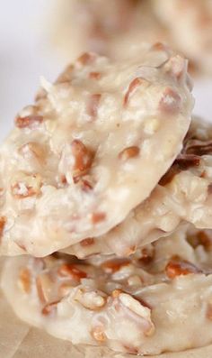 three cookies are stacked on top of each other with white frosting and walnuts