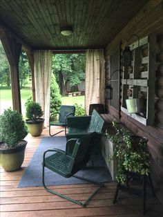 a porch with chairs and potted plants on it