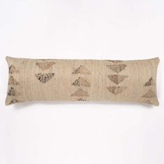 a decorative pillow with an arrow pattern on the front and back, sitting against a white wall