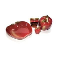 an apple shaped container with two apples in it and one on the ground next to it