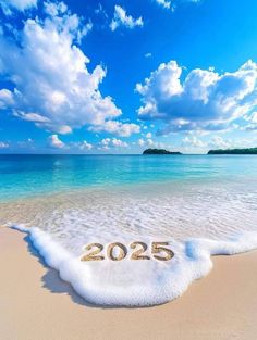 a sandy beach with the number 205 written in sand next to an ocean and blue sky