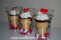 three ice cream cones with hearts on top and candy in the bottom, sitting next to each other