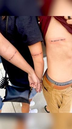 two people holding hands with tattoos on their stomachs and the words do not disturb others