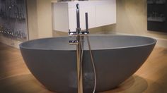 a large gray bath tub sitting on top of a wooden floor