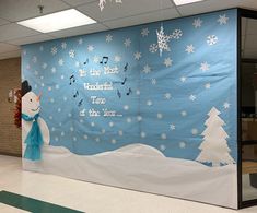 an office cubicle decorated for christmas with snowmen and trees on the front wall